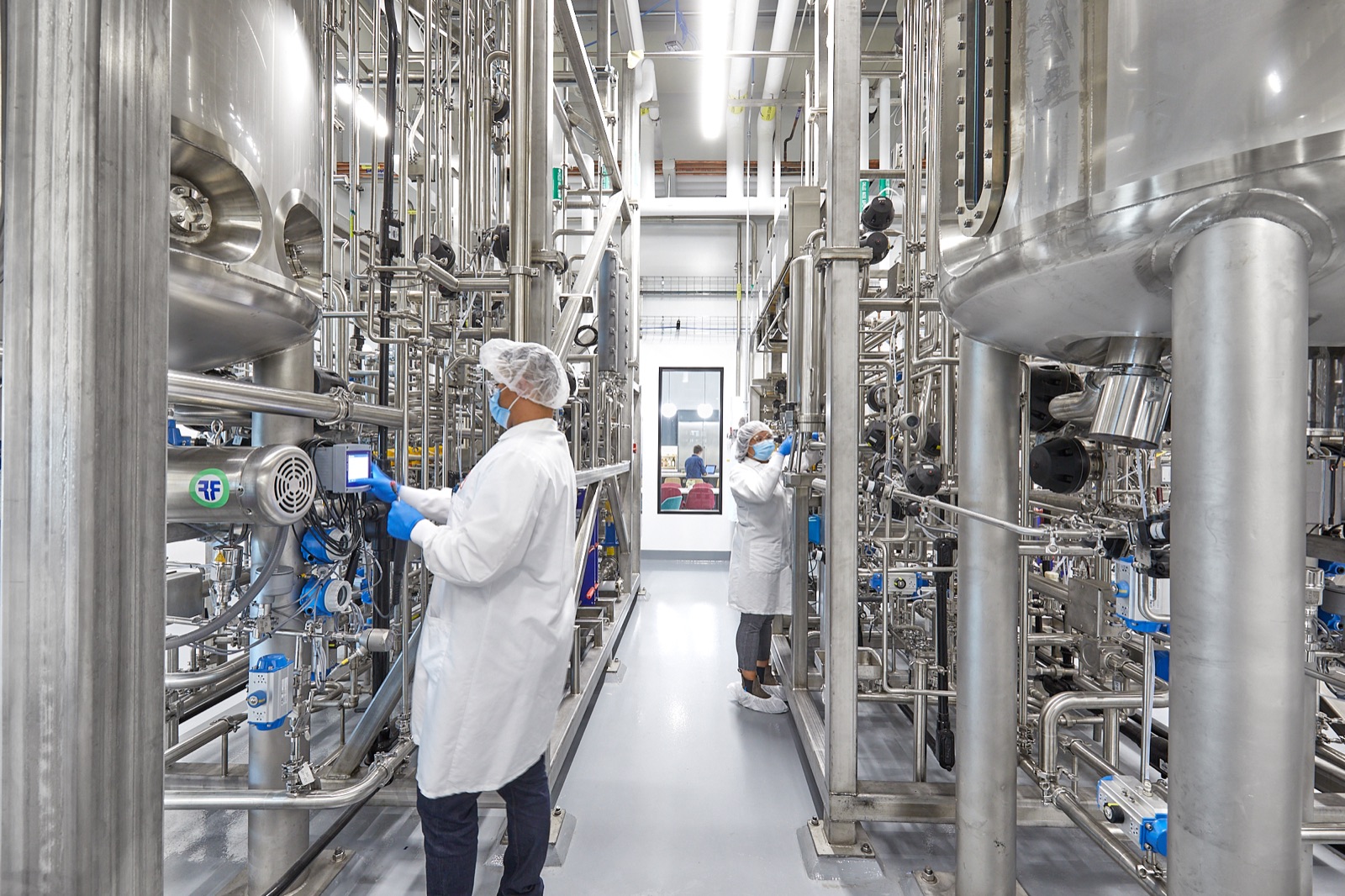 Stainless-steel cultivators, process piping, and operators inside the UPSIDE Foods EPIC production facility.